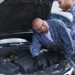 ميكانيكي يفحص محرك سيارة مع صاحبها، حماية المستهلك في ألبرتا