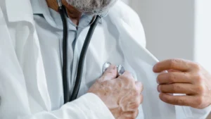 طبيب يرتدي معطفاً أبيض ويمسك سماعة طبية - رخصة مزاولة الطب في كندا