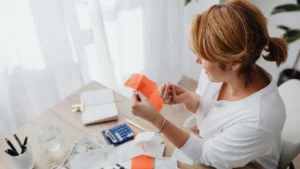 امرأة تراجع إيصالاتها بالآلة الحاسبة استعداداً لاستخدام برامج تقديم الضرائب المجانية في كندا
