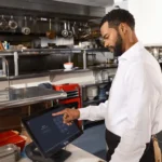 مدير مطعم يتابع الطلبات على شاشة في المطبخ، وظيفة مدير خدمات طعام في هاملتون