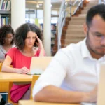 طلاب بالغون يعملون على الحواسيب داخل مكتبة دراسية، الكليات المهنية في أونتاريو وتمويل OSAP