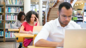 طلاب بالغون يعملون على الحواسيب داخل مكتبة دراسية، الكليات المهنية في أونتاريو وتمويل OSAP